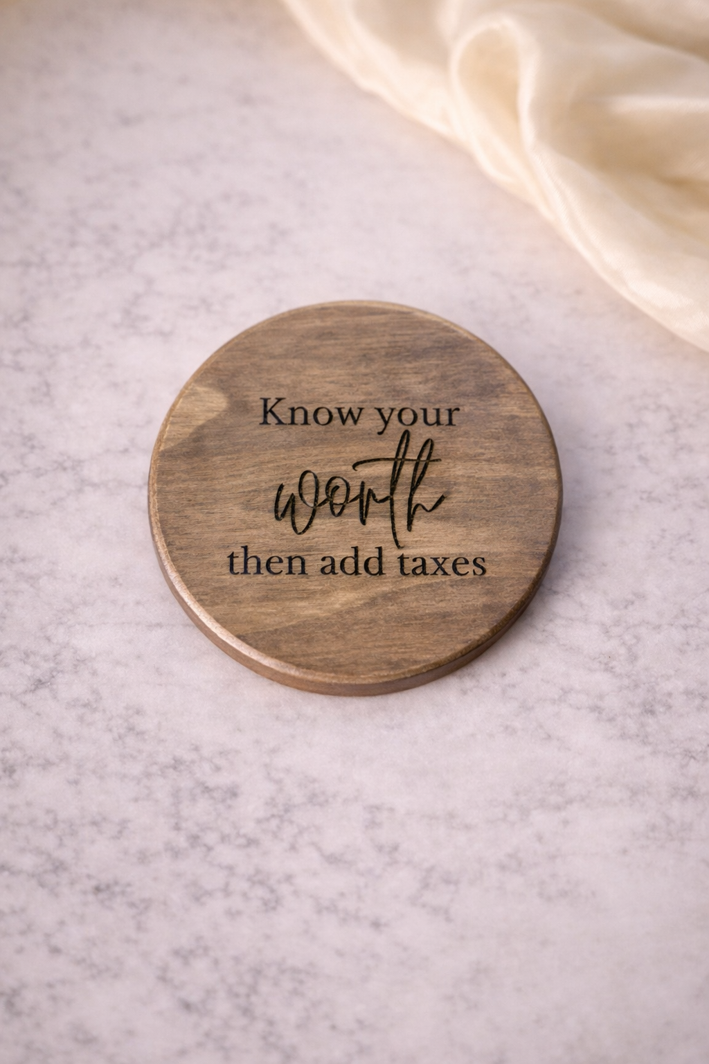 Wooden coaster with engraved text on a light surface
