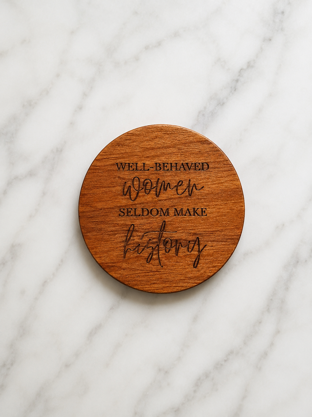 Wooden coaster with engraved text on a marble surface